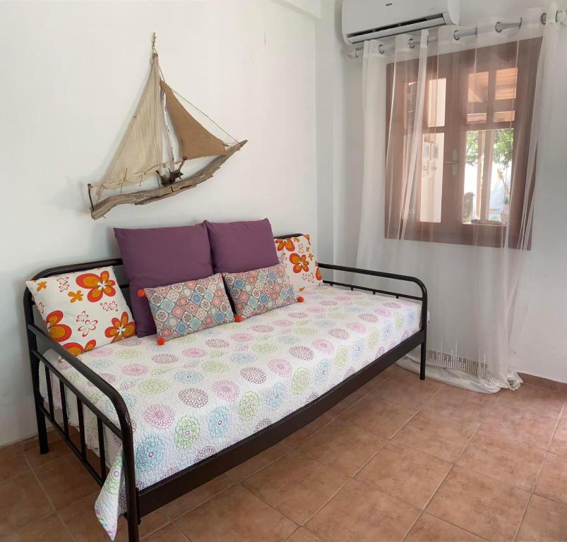 a couch with pillows on it in a room at Nikos & Joanna's appartments in Makry Gialos