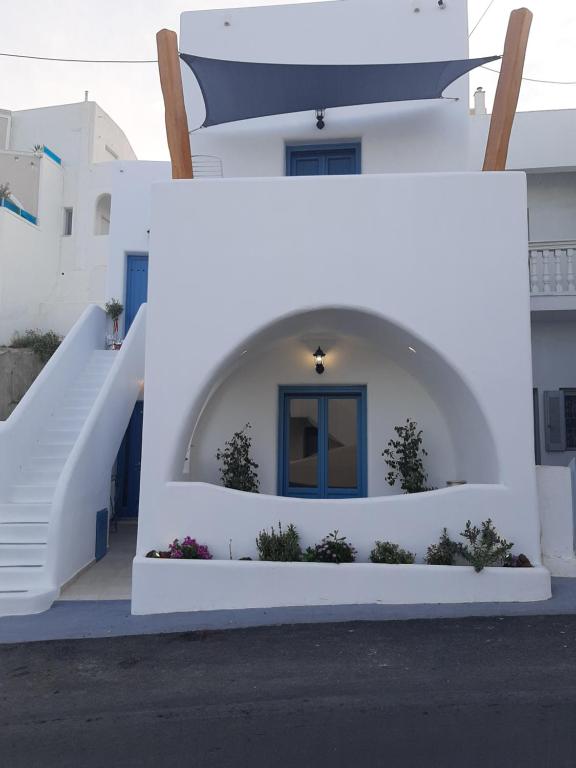 費拉的住宿－Atlantida Spacious Flat，白色的房子,有蓝色的门和楼梯