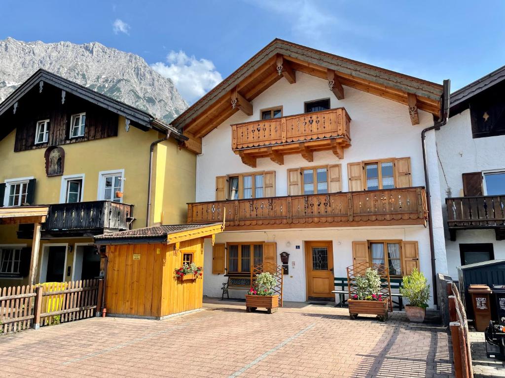 a building with wooden balconies on it with mountains at Ferienwohnung Am Untermarkt in Mittenwald
