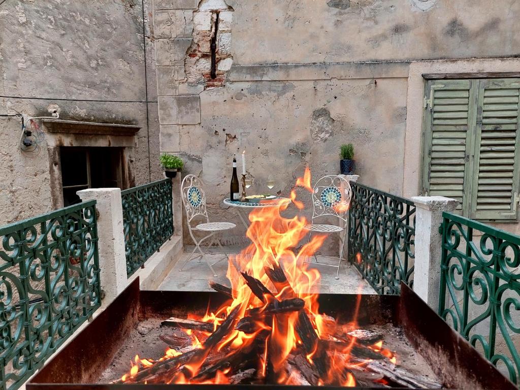 a fire in a courtyard with a table and chairs at V Apartment in Šibenik