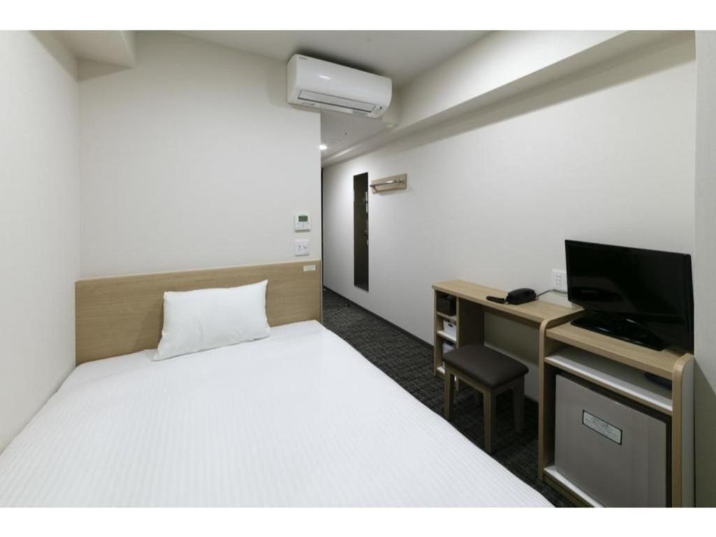 a room with a bed and a desk with a television at R & B Hotel Kyoto Shijo Kawaramachi - Vacation STAY 40548v in Kyoto