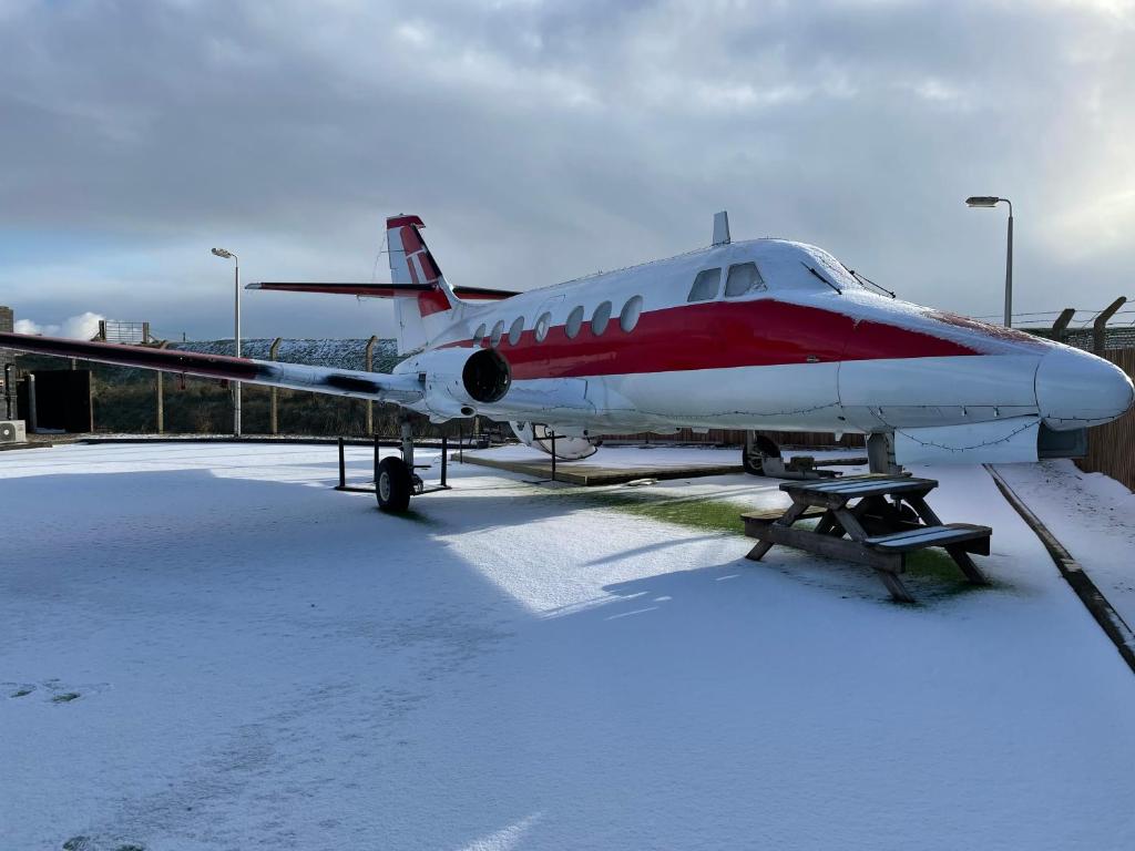a red and white plane parked in the snow at Jetstream in Boston