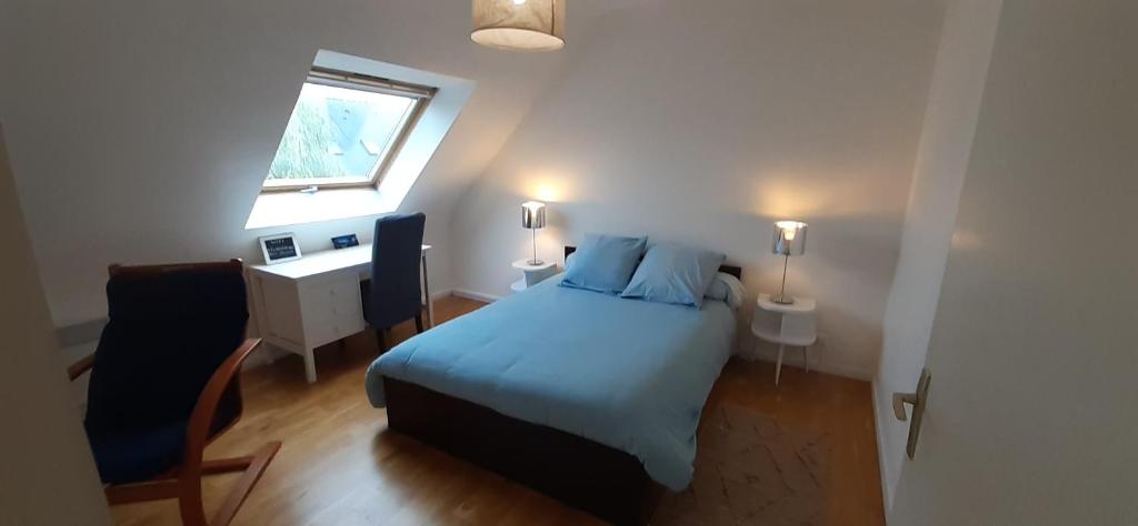 a bedroom with a bed and a desk and a window at Tous à l'ouest in Combrit