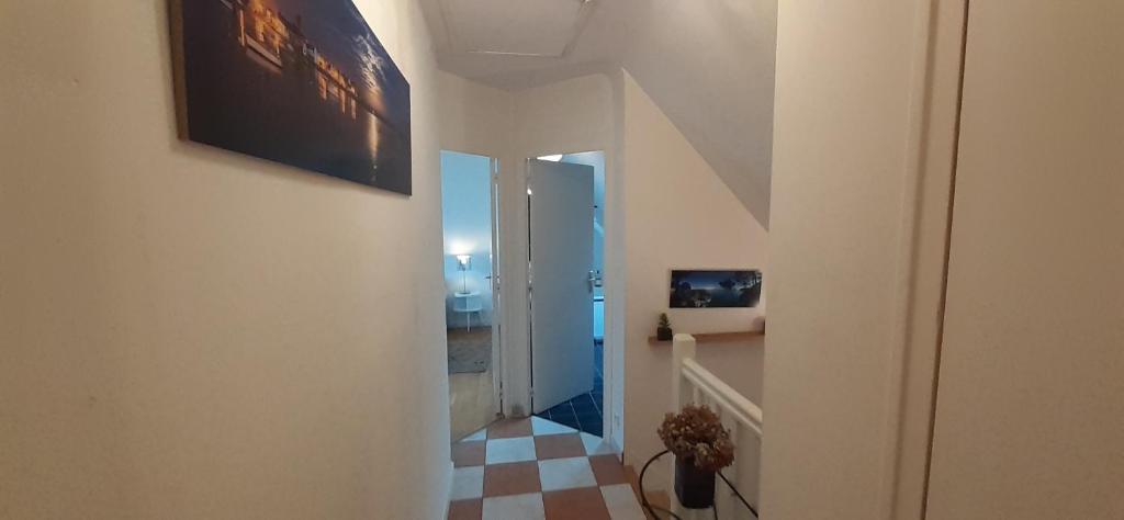 a hallway with a staircase with a checkered floor at Tous à l'ouest in Combrit