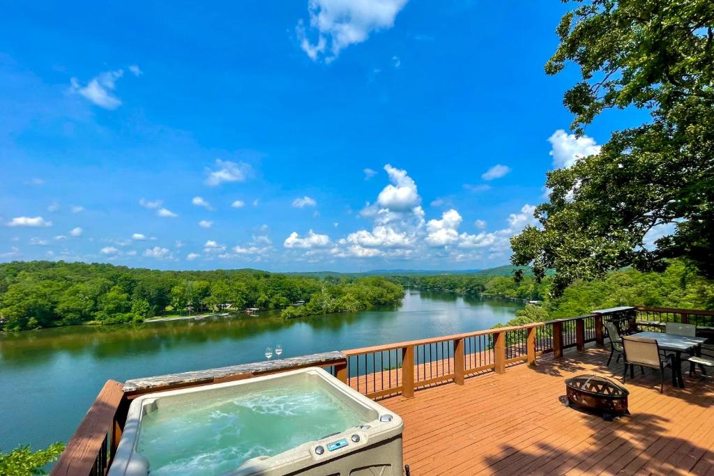 bañera de hidromasaje en una terraza con vistas al río en Lovely Hot Springs Escape with Deck and Hot Tub!, en Hot Springs