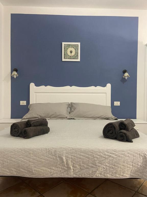 - une chambre bleue avec un lit et des serviettes dans l'établissement Casa ISABELLA loc turist br, à Lipari