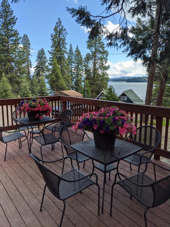 two tables and chairs on a deck with flowers at Camp Almanor at Big Springs in Westwood