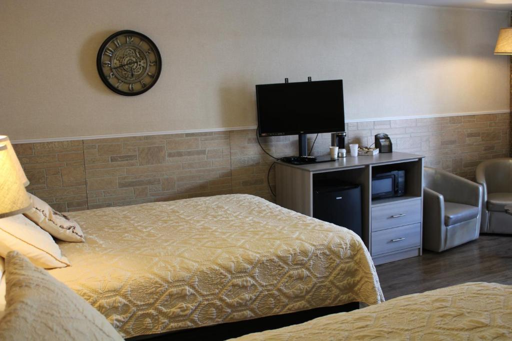 um quarto de hotel com uma cama e uma televisão de ecrã plano em adoba® Lockview em Sault Ste. Marie