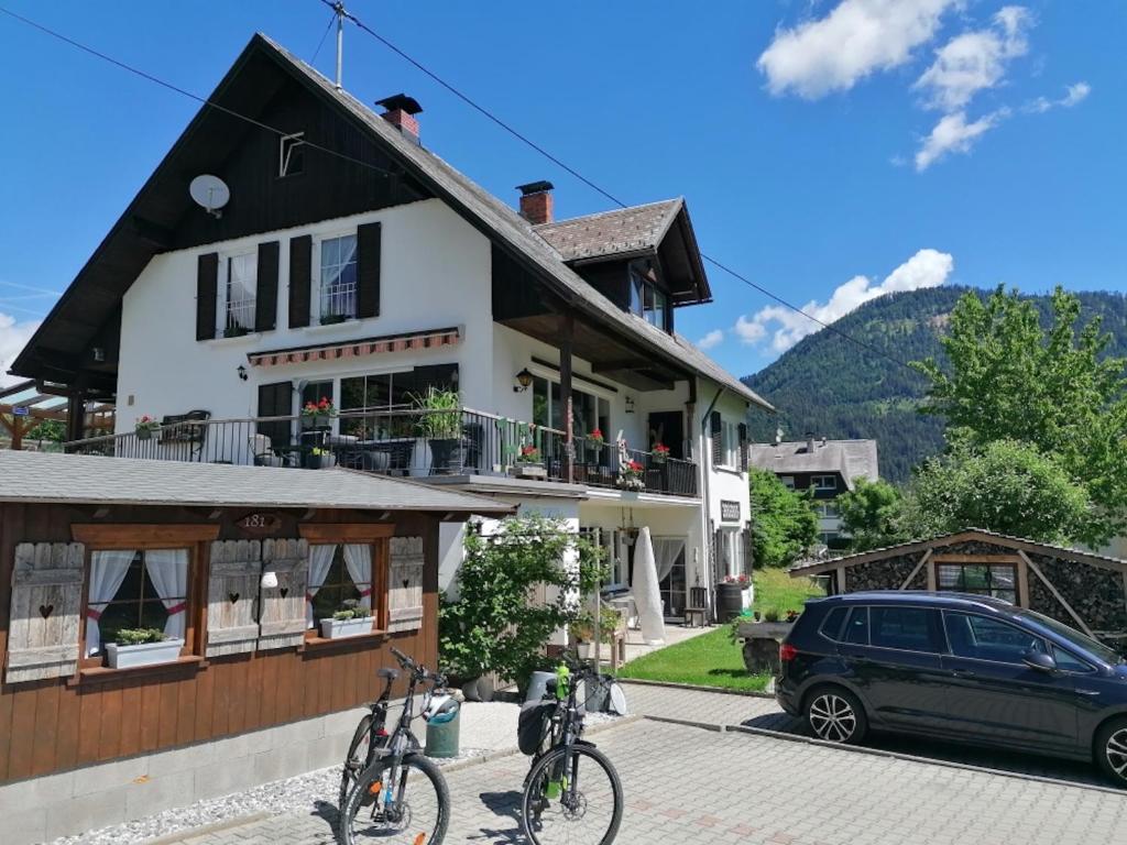 ein Haus mit zwei Fahrrädern davor geparkt in der Unterkunft B&B Haus Holunder Weissbriach in Weissbriach