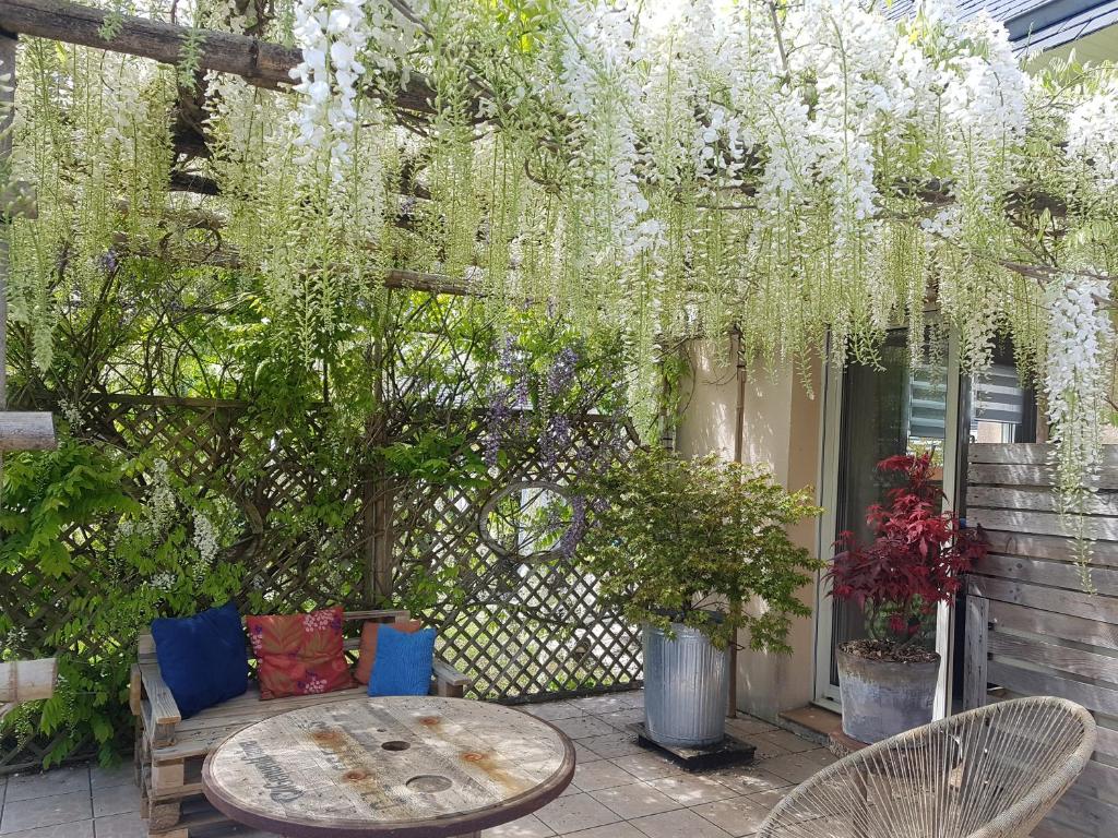 a patio with a table and chairs and flowers at Tous à l'ouest in Combrit