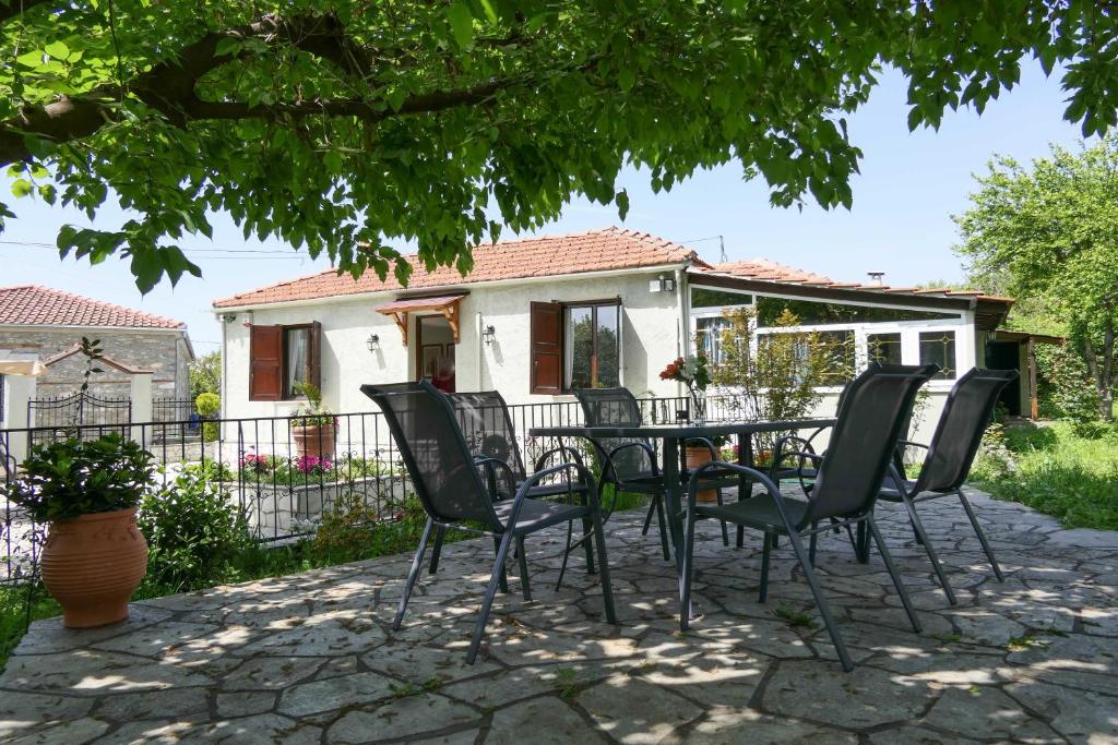 a patio with chairs and a table in front of a house at Anthoulas house in Káto Lekhónia