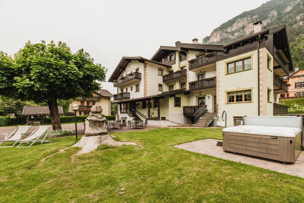 un gran edificio con una cama en un patio en Suàn Hotel, en Ziano di Fiemme