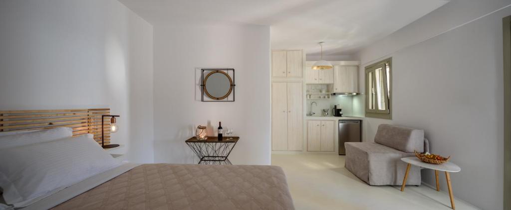 a bedroom with a bed and a chair and a kitchen at ASTRAVI in Kimolos