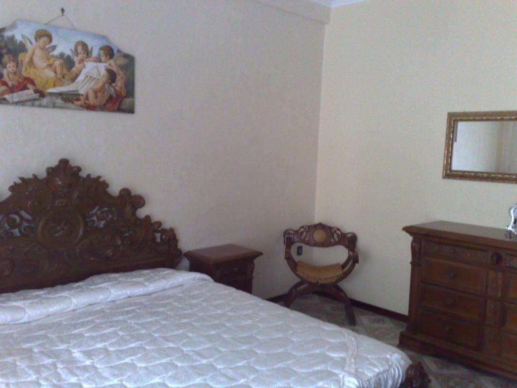 a bedroom with a bed and a dresser and a mirror at Apartment Angioletta in Manfredonia