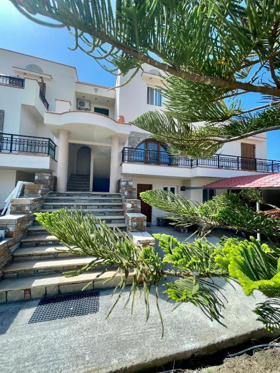 a house with stairs and palm trees in front of it at Tranquil Apartments in Naxos Chora