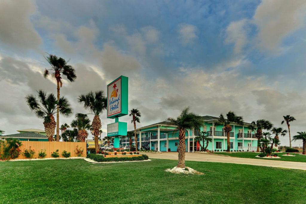 a hotel with a palm tree in front of it at Island Hotel Port Aransas in Port Aransas