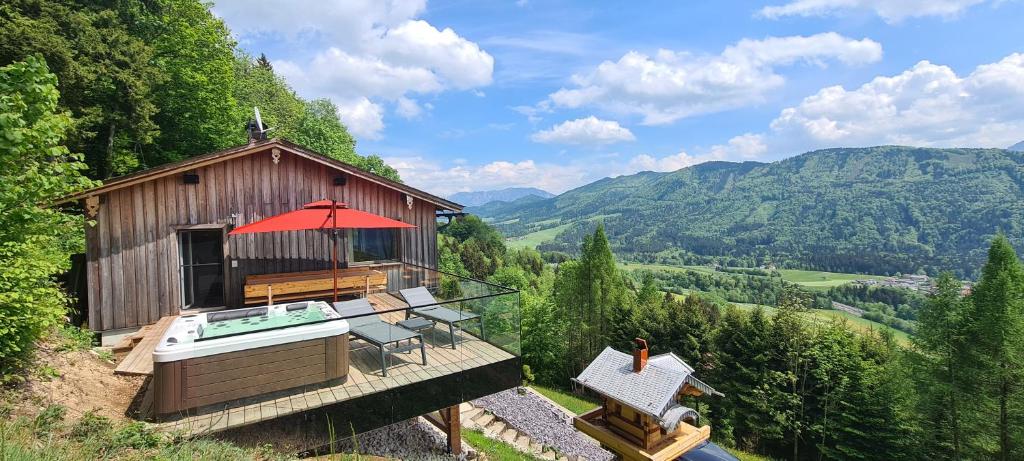 un pequeño edificio con bañera de hidromasaje en una terraza en Ruhige Bergvilla in Alleinlage am Mondsee mit Seeblick Bergblick und Whirlpool en Innerschwand