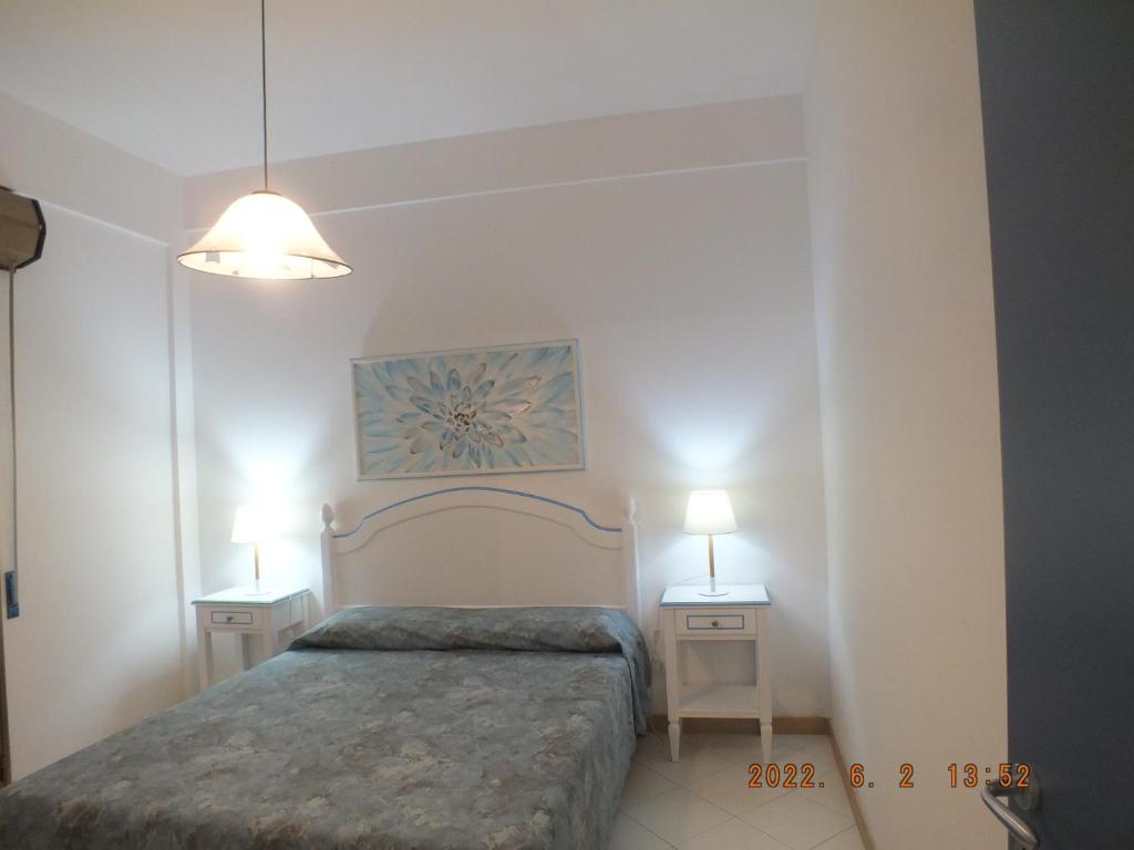 um quarto com uma cama e duas mesas de cabeceira em Villa Isolde em Triscina