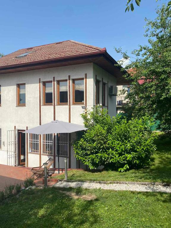 a house with an umbrella in front of it at Villa Anni in Sarajevo