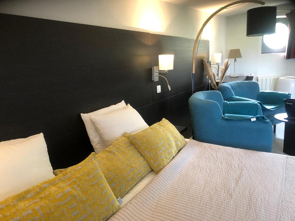 een hotelkamer met een bed en een blauwe stoel bij La suite cosy de Julie , 2 pièces 3 lits parking privé Résidence Cosyade in Bourbourg