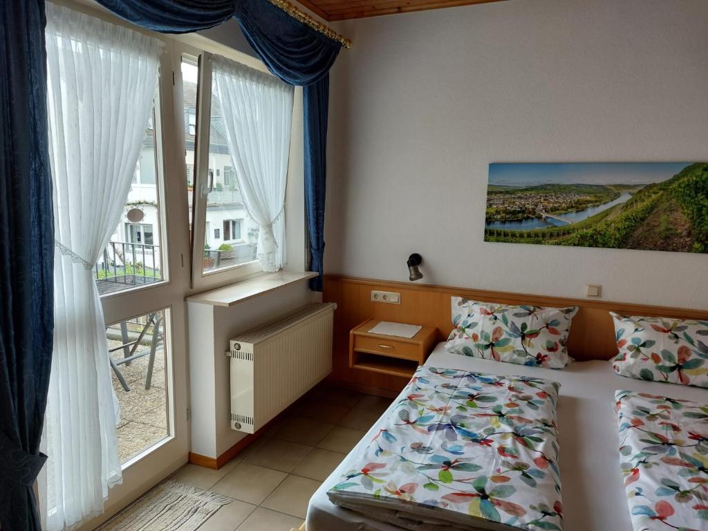 a hotel room with two beds and a window at Gästehaus Annette Hermes-Hoffmann in Trittenheim