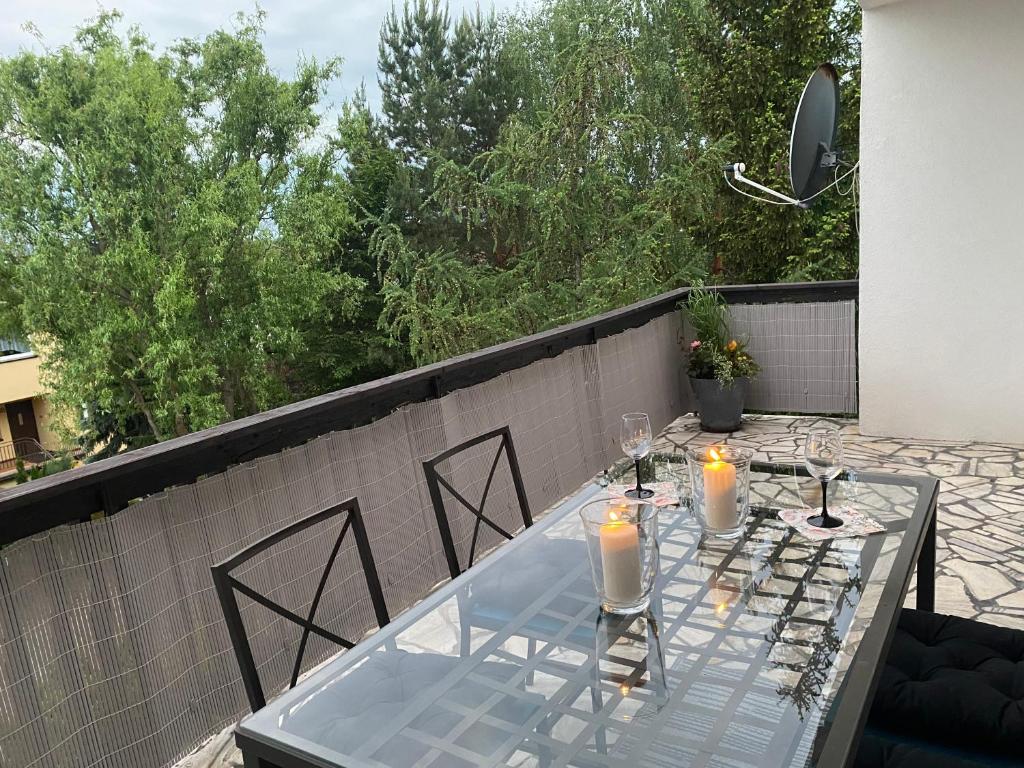 uma mesa de vidro com velas em cima de um pátio em Apartament w ZIELONEJ OKOLICY z TARASEM em Kielce