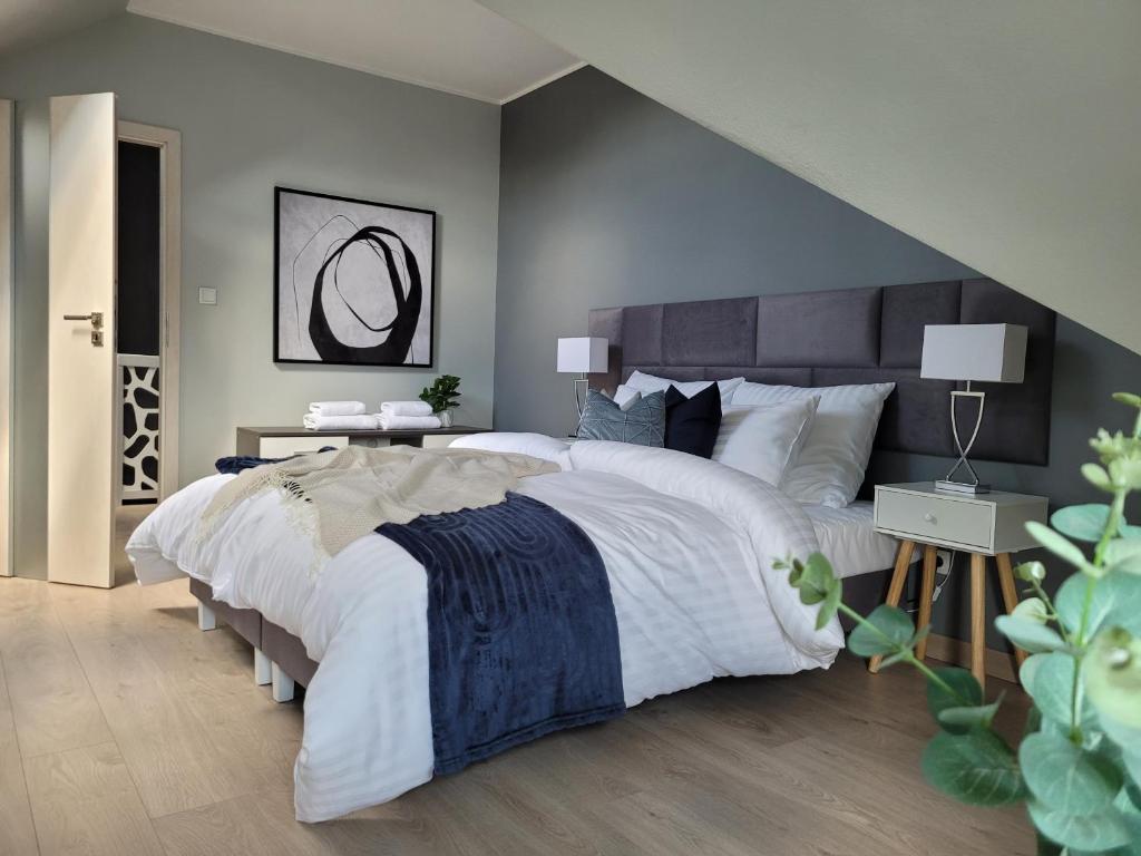 sypialnia z dużym łóżkiem z dużą białą narzutą w obiekcie Apartament Penthouse z widokiem na Śnieżkę i prywatnym parkingiem - by SpaceApart w Jeleniej Górze