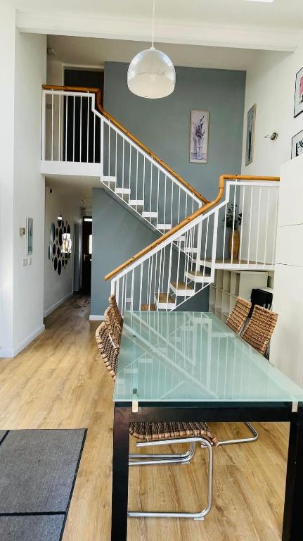a dining room with a glass table and stairs at Modern City Centre House in Galway
