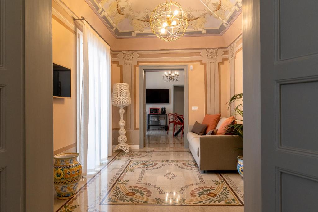 un soggiorno con divano e lampadario pendente di Palazzo Guajana a Trapani