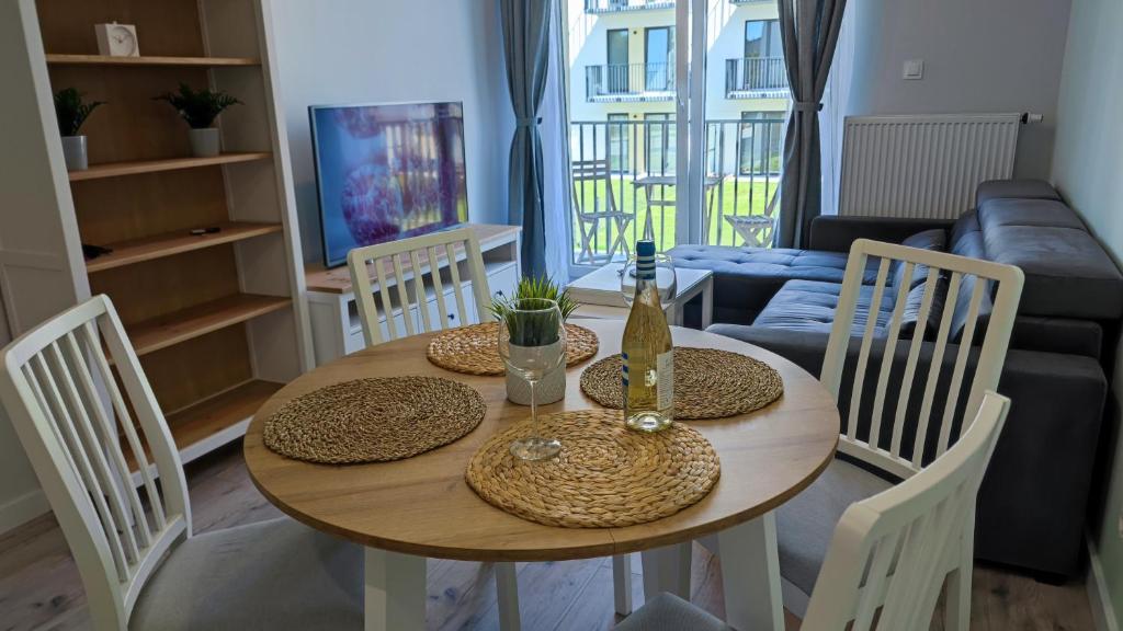 a dining room table with two chairs and a couch at Apartament Korfu Jastrzębia Góra in Jastrzębia Góra