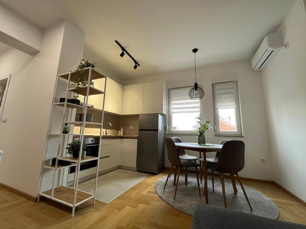 eine Küche und ein Esszimmer mit einem Tisch und Stühlen in der Unterkunft Apartman Lukana lll Banjaluka in Banja Luka
