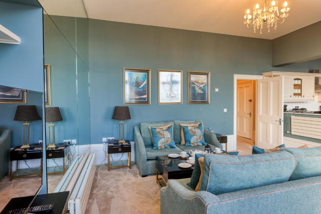 ein Wohnzimmer mit blauen Wänden und blauen Möbeln in der Unterkunft The Regency - Sea views and a modern art deco style interior in Ramsgate