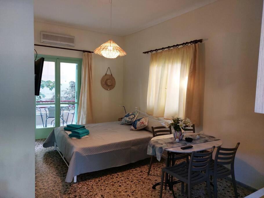 a bedroom with a bed and a table with chairs at Vitamin sea Apartment 4, Άνετο διαμέρισμα. in Almiropotamos