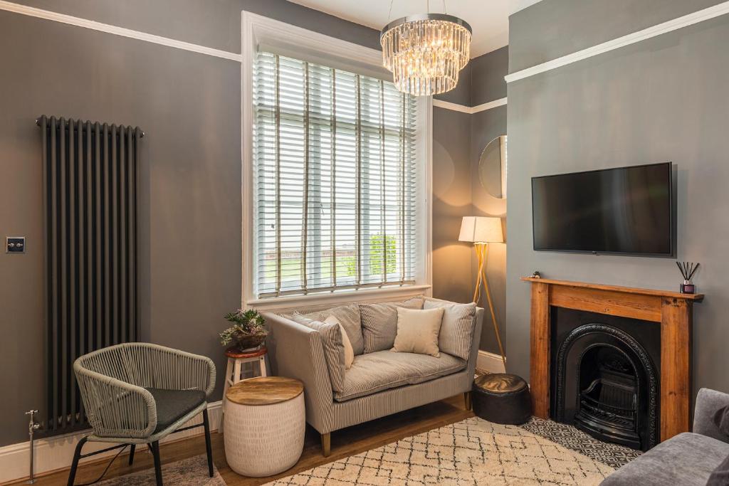 a living room with a chair and a fireplace at Coastal Cottage: Charming three bedroom cottage with private garden in Ramsgate