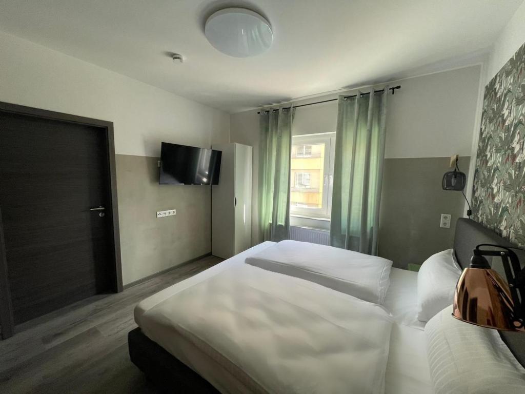 a hotel room with a bed and a television at Haus 15 Apartments in Bielefeld