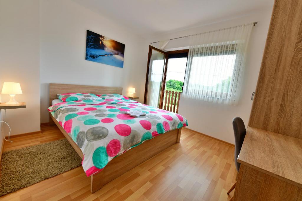 una camera da letto con un letto con un piumone colorato di Apartman Mate a Rakovica
