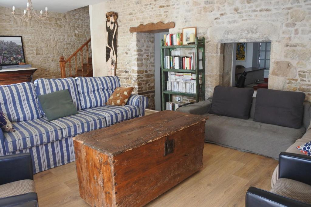 uma sala de estar com sofás e uma mesa com um baú em Maison de village spacieuse et confortable em Le Gué-de-Velluire