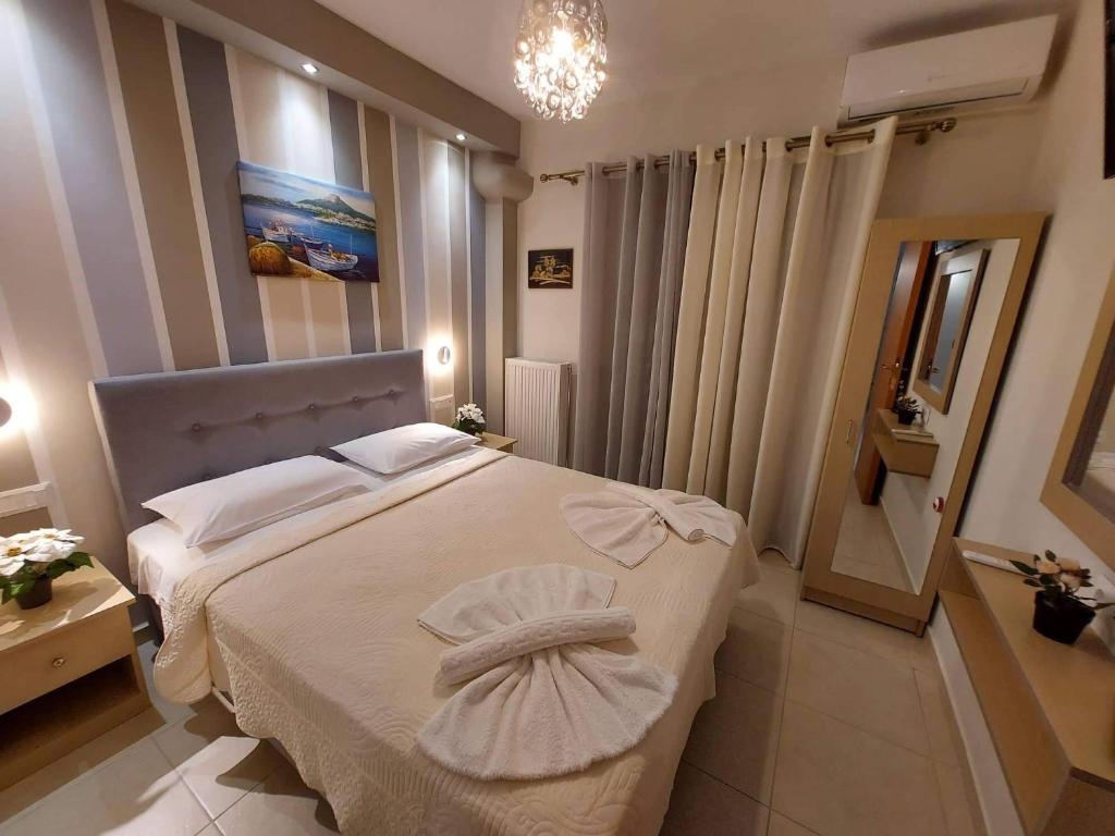 a bedroom with a large white bed with a mirror at Modern Apartment Kallithea 1 in Kallithea Halkidikis