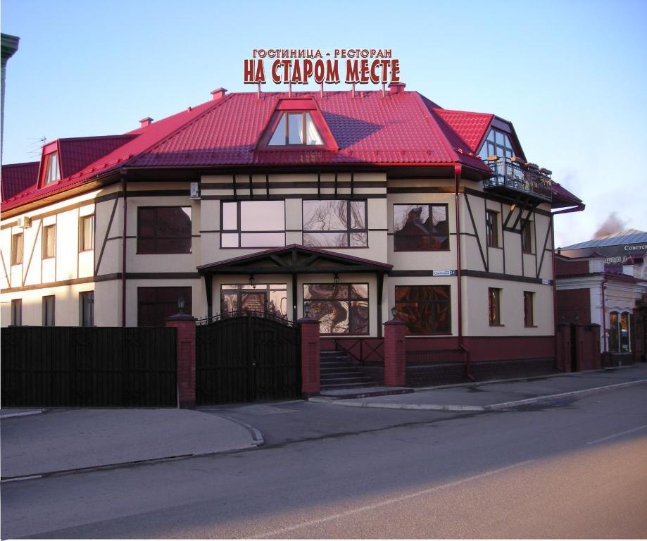 een groot wit gebouw met een rood dak bij Hotel Na starom meste in Biejsk