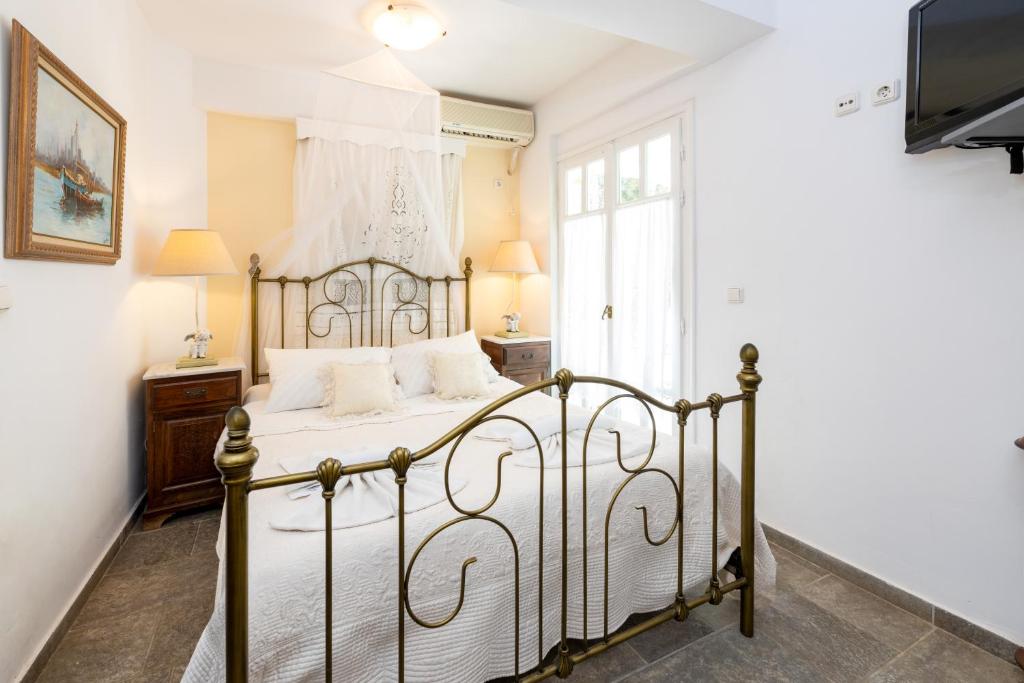 a bedroom with a metal bed with white sheets at Villa Areto in Kamares
