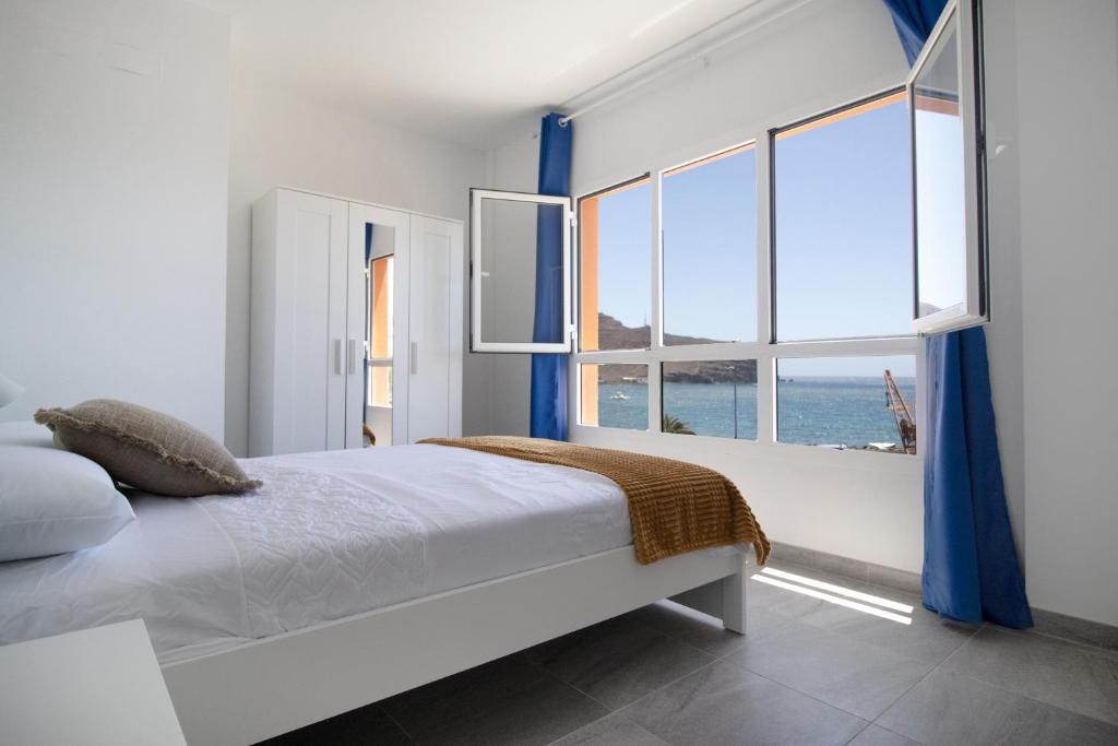 a bedroom with a bed and a large window at Casa Playa Chica in Gran Tarajal