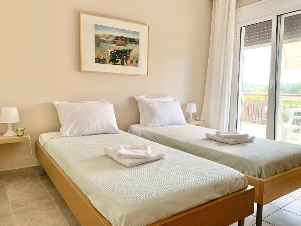 two beds in a room with a window at Lovely apartment by the sea 2 ….. in Epanomi