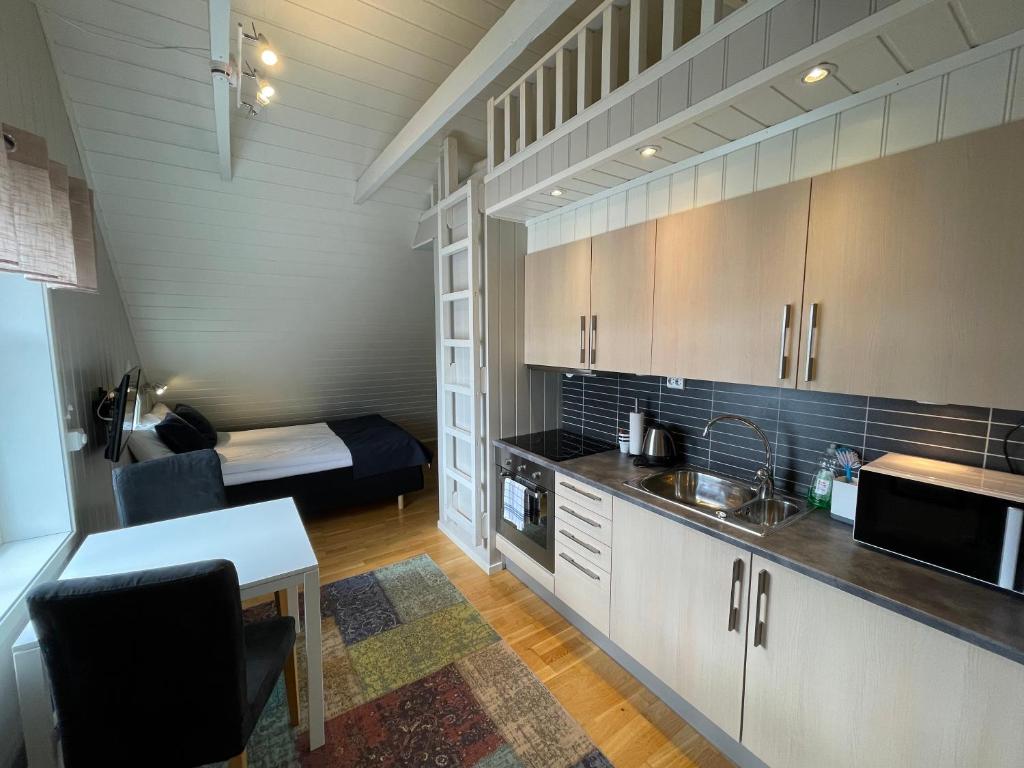 a kitchen with a table and a room with a bed at Novatind - Studio apartment with free parking in Narvik