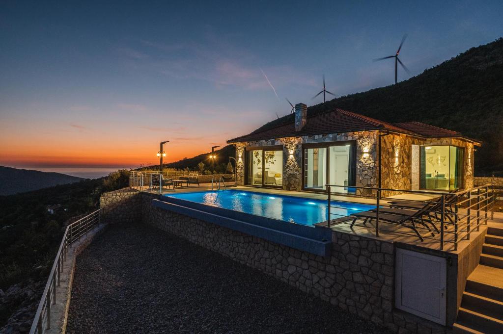 a villa with a swimming pool in front of a house at Vila katune 2022 in Ulcinj