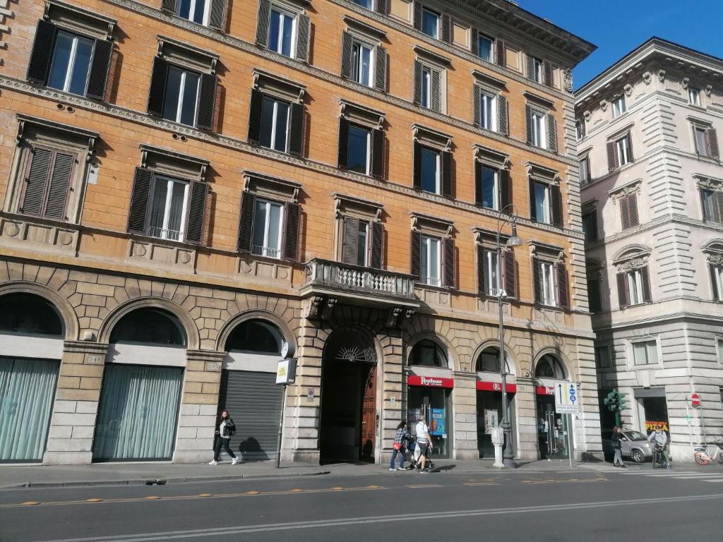dos edificios en una calle con gente caminando delante de ellos en Vittorio Emanuele, en Roma