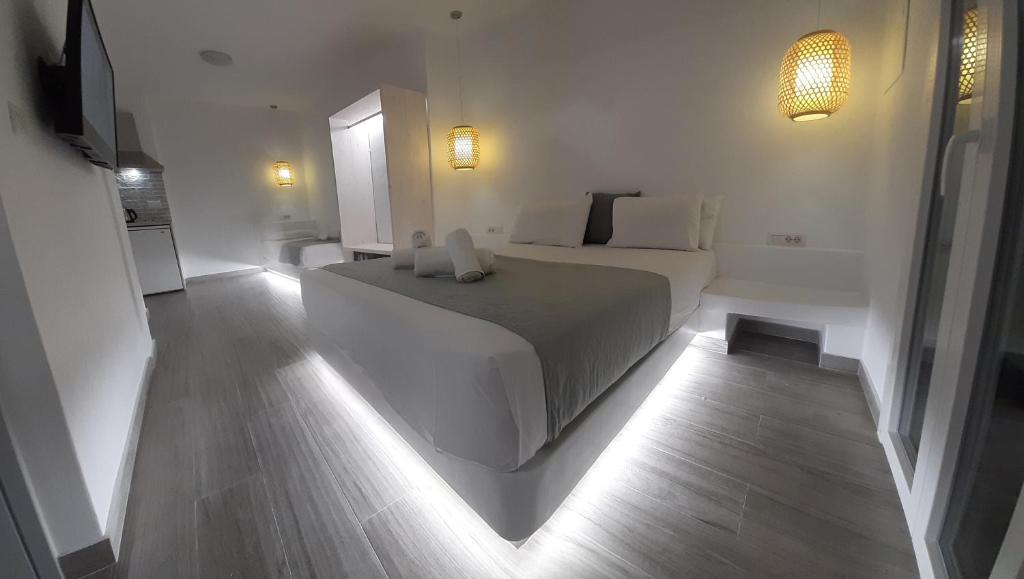 a white bedroom with a bed and a television at Maria's View Delux in Ios Chora