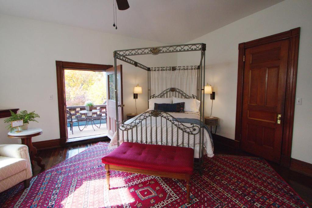 1 dormitorio con cama con dosel y banco rojo en Louisville Bourbon Inn en Louisville