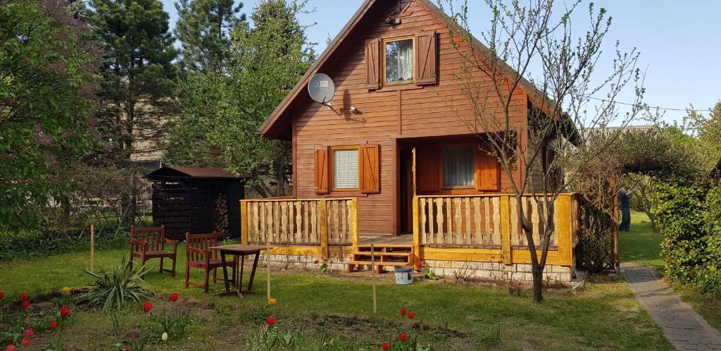 a house with a table and chairs in front of it at Szyszka i Róża Domek na Jurze in Zelasko