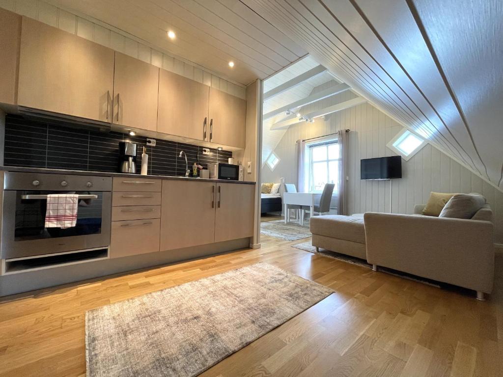 sala de estar con sofá y cocina en Presttind - Studio apartment with free parking, en Narvik