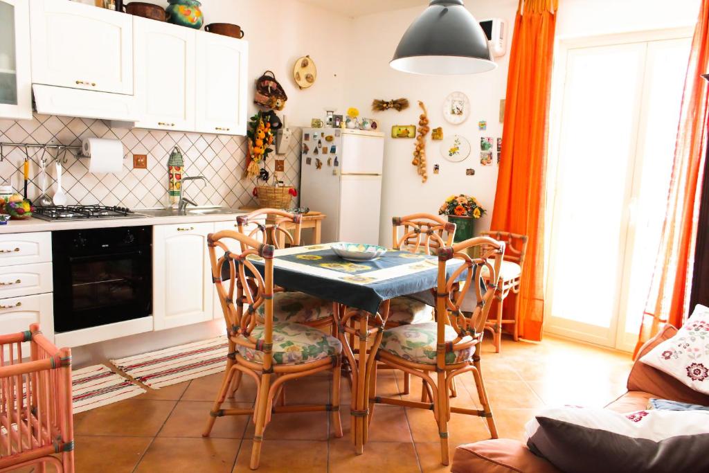 AragonaにあるBed and breakfast Agrumi in terrazzaのキッチン(テーブル、椅子、冷蔵庫付)